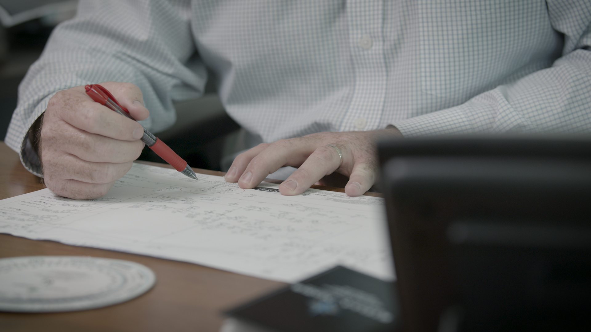 image of a person reviewing blue prints for a custom manufactured SKID
